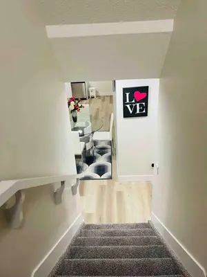 a staircase leading to a room with a chair and a desk at Modern suite in basement Upland in Edmonton