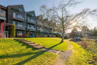 a building with a tree in the middle of a yard at Tofino Eco Waterfront Condo in Tofino