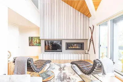 a living room with two chairs and a fireplace at Premium 4-Bedroom Chalet in Whistler