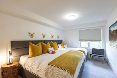 a bedroom with a large bed with yellow pillows at Premium 4-Bedroom Chalet in Whistler