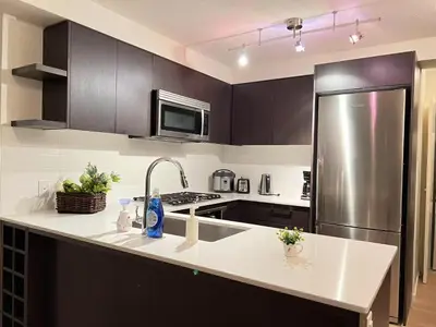 a kitchen with a sink and a refrigerator at Fabulous and convenient 2B2B close to Richmond center in Richmond