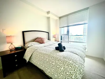 a bedroom with a large bed and a large window at Fabulous and convenient 2B2B close to Richmond center in Richmond