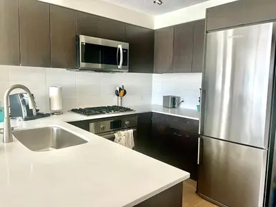 a kitchen with a stainless steel refrigerator and a sink at Fabulous and convenient 2B2B close to Richmond center in Richmond