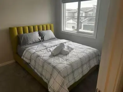 a bed with a stuffed animal on top of it at Brand New Bedroom in Keswick A in Edmonton