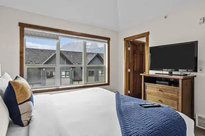 a bedroom with a large bed and a large window at Peaks and Patio 3 Bedroom managed by Little Sister Getaways in Canmore