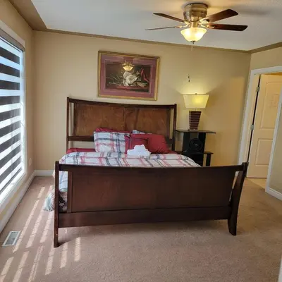 a bed in a room with a ceiling fan at Ogden 3-Bed Home in Calgary