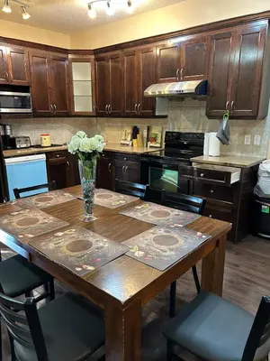 a kitchen with a wooden table with a vase of flowers on it at Ogden 3-Bed Home in Calgary