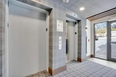a hallway with tiled walls and doors with a window at 3 Bedroom with Heated Outdoor Pool and Hottub! in Canmore