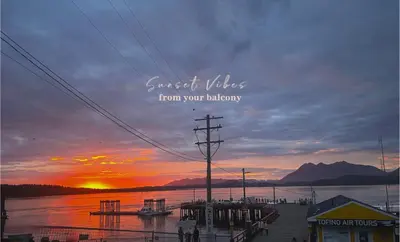 a sunset over a body of water with a pier at Tofino Waterfront Condo in Tofino
