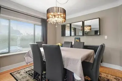 a dining room with a table and chairs and a chandelier at Lovely 2 Bedroom Kits Home - Walk to the Beach in Vancouver