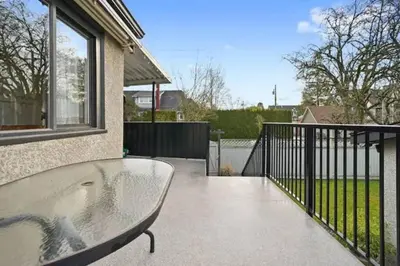 a glass table on a balcony of a house at Lovely 2 Bedroom Kits Home - Walk to the Beach in Vancouver