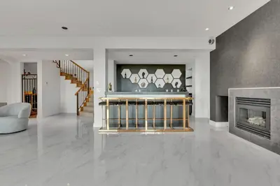 a living room with a fireplace and a staircase at Beautiful 5 bedroom West Vancouver Mansion in West Vancouver