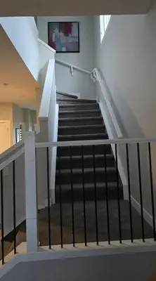 a staircase in a building with white rails at Cornerstone 4-Bed Home in Calgary