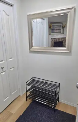 a room with a mirror and a shelf in front of a fireplace at Magnificent 3-Bed Home in Calgary