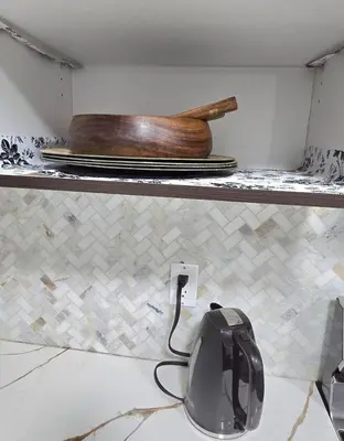 a kitchen counter with a shelf with plates and a wooden bowl at Magnificent 3-Bed Home in Calgary