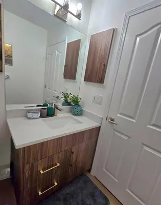 a bathroom with a sink and a mirror and a door at Magnificent 3-Bed Home in Calgary