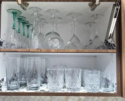 a bunch of glasses sitting on a shelf at Magnificent 3-Bed Home in Calgary