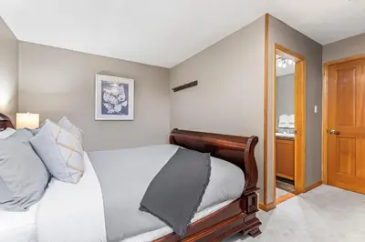 a bedroom with a bed with a wooden frame at 2BR and Loft in Wildwood Lodge, Mountain Views, Close to Ski Hill, Common Hot Tub, Fireplace, Parking in Whistler
