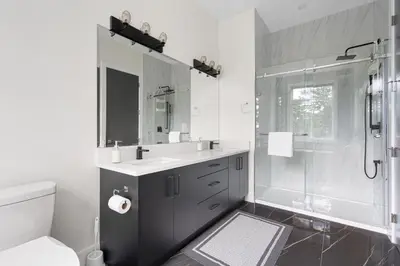 a white bathroom with a sink and a shower at Stylish Retreat in Agassiz with Scenic Views in Agassiz