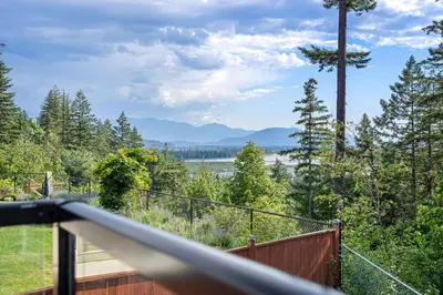 a balcony with a view of a river and trees at Stylish Retreat in Agassiz with Scenic Views in Agassiz