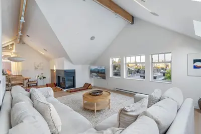 a living room with a white couch and a table at Beautiful, Newly Renovated Creek Home in Vancouver