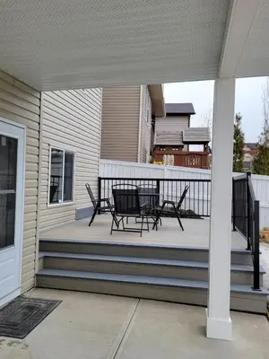 a porch with two chairs and a table on it at Cozy and Modern Suite - Your Home Away from Home! in Calgary