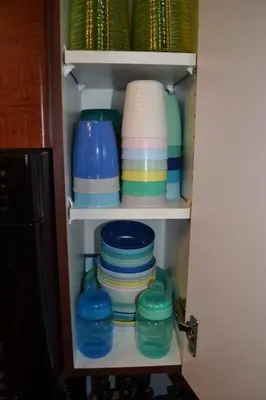 a cupboard filled with plates and bowls and dishes at The Beach House Pool Access 5 Min Walk to Lake Sleeps 8 in Invermere