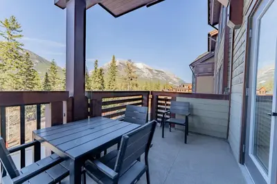 a table and chairs on the balcony of a house at Stunning 2bd hot tub walking distance to downtown in Canmore