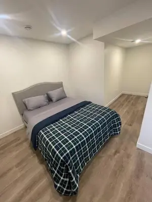 a bedroom with a bed with a plaid blanket at Bedroom in Southwest C in Edmonton