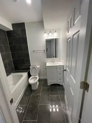 a bathroom with a toilet and a tub and a sink at Bedroom in Southwest C in Edmonton