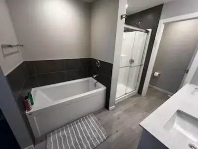 a bathroom with a tub and a shower and a sink at Brand New Bedroom with private bathroom in Keswick in Edmonton