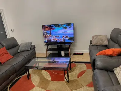 a living room with two couches and a flat screen tv at Bedroom in Upland A in Edmonton