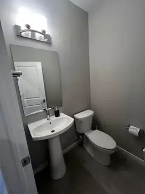 a white bathroom with a toilet and a sink at Bedroom in Upland B in Edmonton