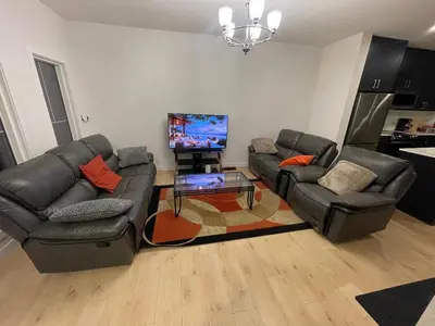 a living room with two couches and a flat screen tv at Bedroom in Upland B in Edmonton
