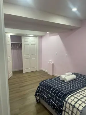 a bedroom with a bed with a blue and white blanket at Bedroom in Upland C in Edmonton