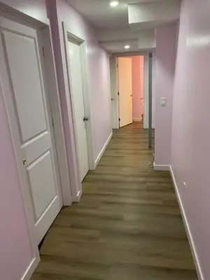 an empty hallway with pink walls and wooden floors at Bedroom in Upland D in Edmonton