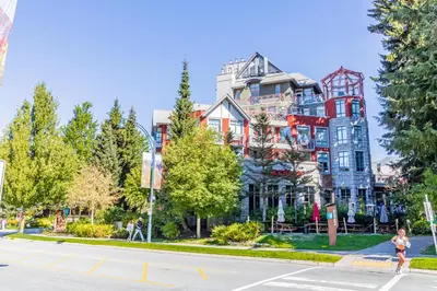 a woman crosses a street in front of a large building at Alpenglow Lodge by Elevate Vacations in Whistler