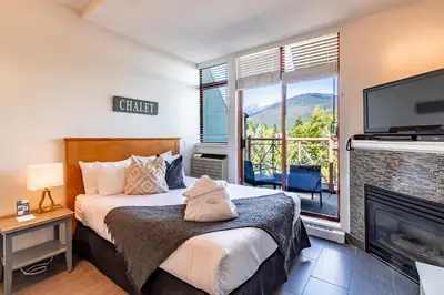 a bedroom with a bed and a fireplace and a tv at Alpenglow Lodge by Elevate Vacations in Whistler