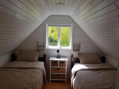 two beds in a attic room with a window at Cozy Cabin, 2 min to the HWY1 in Tappen