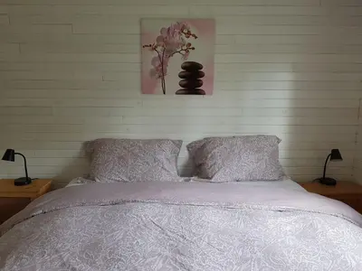 a bedroom with a bed and a vase of flowers on the wall at Cozy Cabin, 2 min to the HWY1 in Tappen