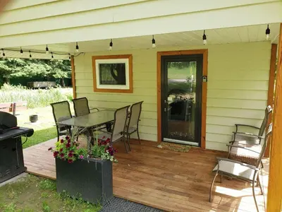 a patio with a table and chairs on a deck at Cozy Cabin, 2 min to the HWY1 in Tappen