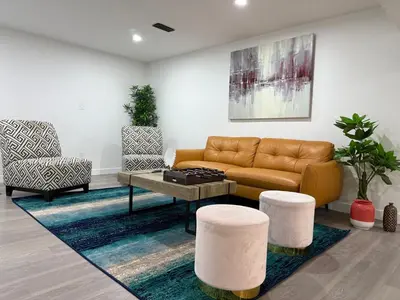 a living room with a couch and two chairs at THE GUEST HOUSE WEST EDMONTON Mall in Edmonton