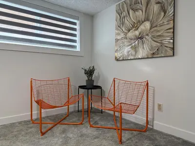two chairs and a table in a room with a painting at THE GUEST HOUSE WEST EDMONTON Mall in Edmonton