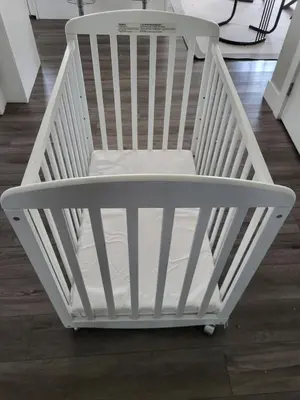a white crib in a room with a wooden floor at Happy Zone Suite - Sleeps 4, Free Treats ! in Langford