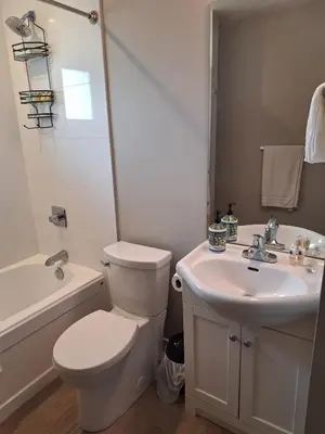 a white bathroom with a toilet and a sink at Happy Zone Suite - Sleeps 4, Free Treats ! in Langford