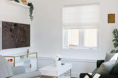 a living room with a window and a couch and a table at Brass Apple Cottage in Campbell River