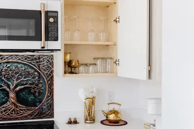 a kitchen with a microwave over a stove with a counter at Brass Apple Cottage in Campbell River