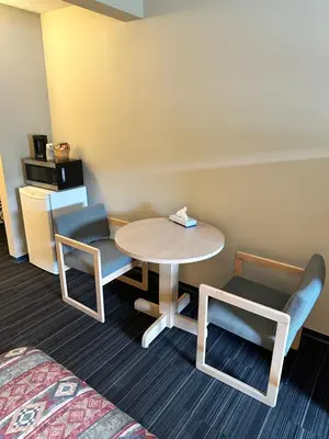 a room with a table and two chairs and a bed at Fortunes Landing Motor Inn in Enderby