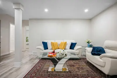 a living room with two white couches and a glass table at Modern 2BR Private Suite NW Near Airport & Amazing Shopping! Free Banff Pass, Netflix, Parking! in Calgary