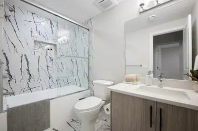 a bathroom with a toilet and a sink and a mirror at Modern 2BR Private Suite NW Near Airport & Amazing Shopping! Free Banff Pass, Netflix, Parking! in Calgary